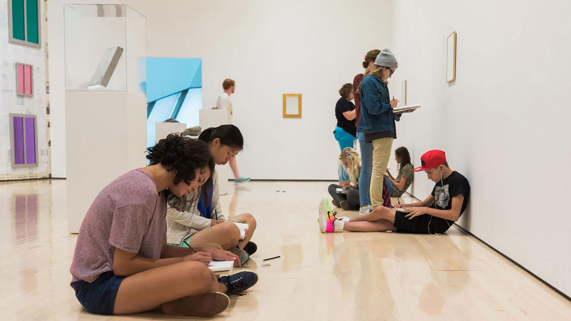 People sitting on a art gallery floor